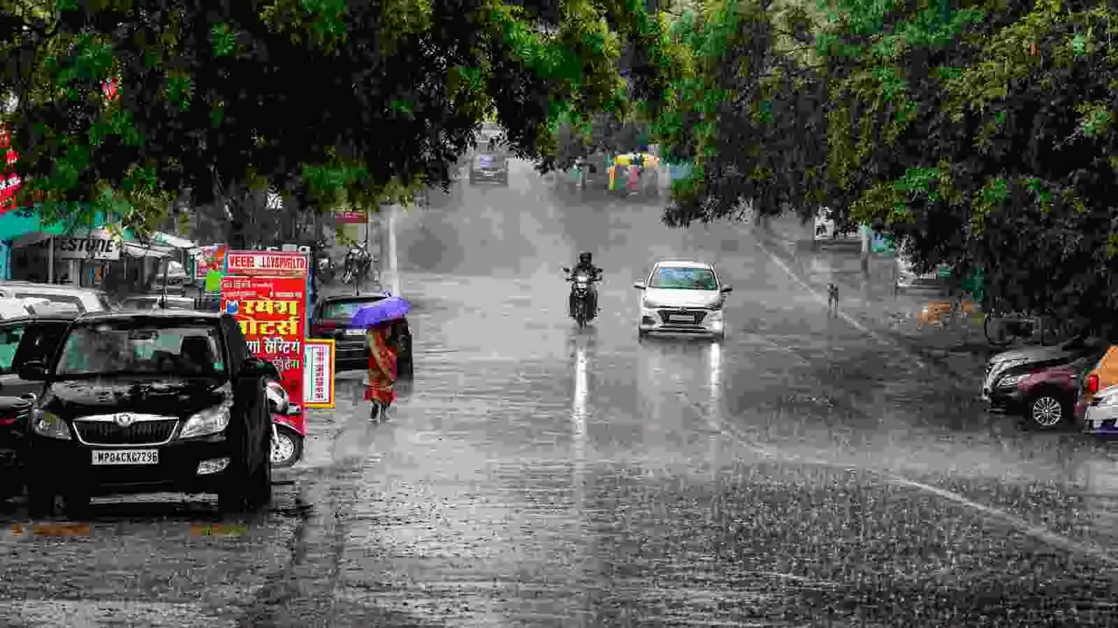 दक्षिण भारत में बारिश के दौरान सड़क पर चलते हुए लोग और वाहन। दक्षिण भारत में बारिश के दौरान सड़क पर चलते हुए लोग और वाहन।