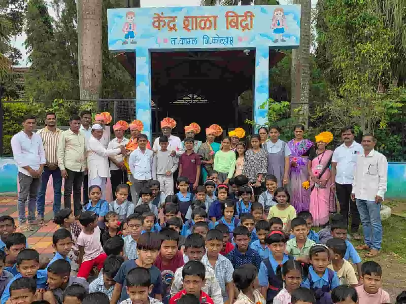 केंद्रशाला बिद्री के प्रवेश द्वार पर फेटा पहने शिक्षक और बैठे छात्र सामूहिक चित्र में।