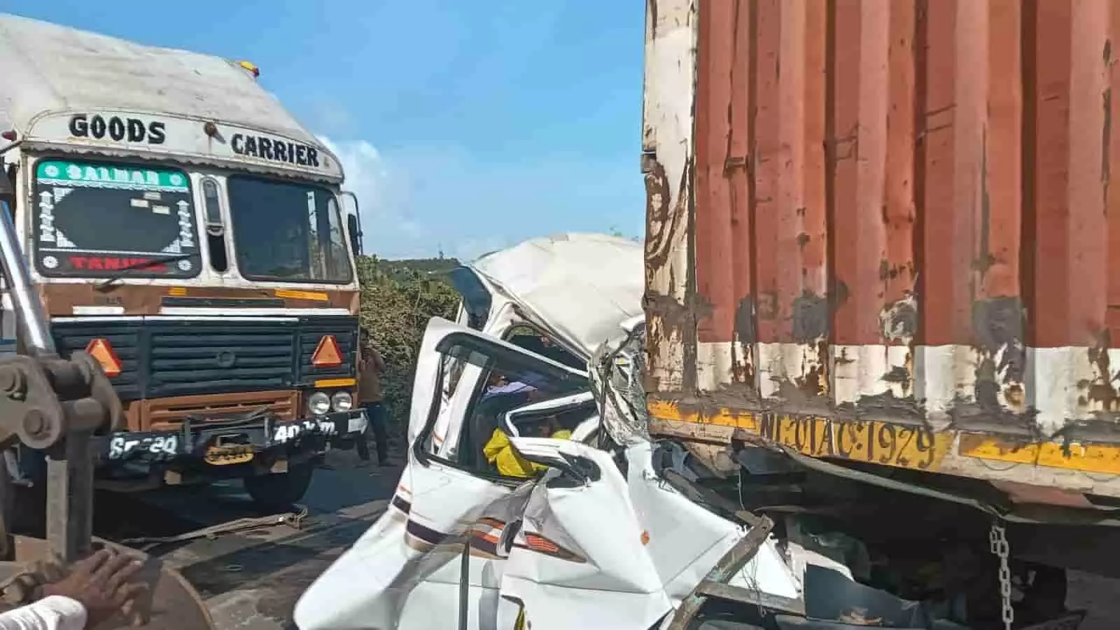 सड़क दुर्घटना के बाद दो ट्रकों के बीच दबी हुई एक क्षतिग्रस्त कार दिख रही है। सड़क दुर्घटना के बाद दो ट्रकों के बीच दबी हुई एक क्षतिग्रस्त कार दिख रही है।