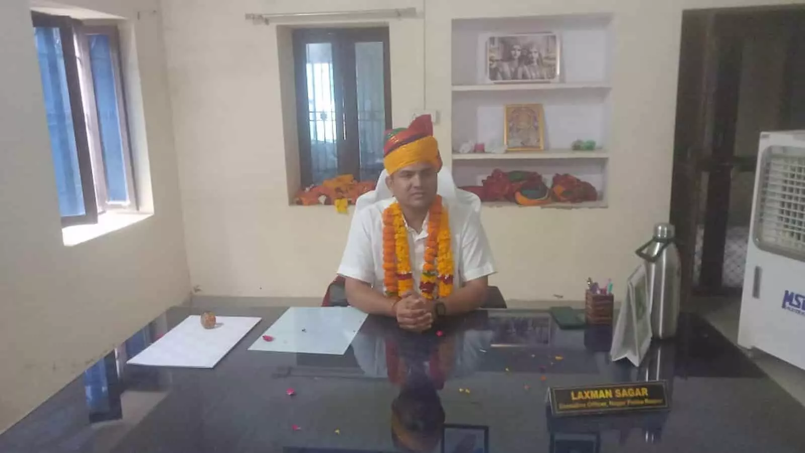 तस्वीर में दिख रहे अधिशासी अधिकारी लक्ष्मण सागर रायपुर नगर पालिका कार्यालय में पदभार ग्रहण कर बैठे हैं।