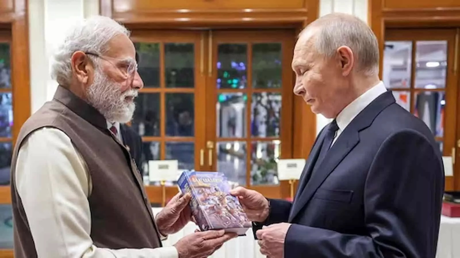 एक इनडोर बैठक के दौरान प्रधानमंत्री नरेंद्र मोदी और रूसी राष्ट्रपति व्लादिमीर पुतिन को हाथ में पुस्तक थामे बातचीत करते हुए दिखाया गया है। एक इनडोर बैठक के दौरान प्रधानमंत्री नरेंद्र मोदी और रूसी राष्ट्रपति व्लादिमीर पुतिन को हाथ में पुस्तक थामे बातचीत करते हुए दिखाया गया है।