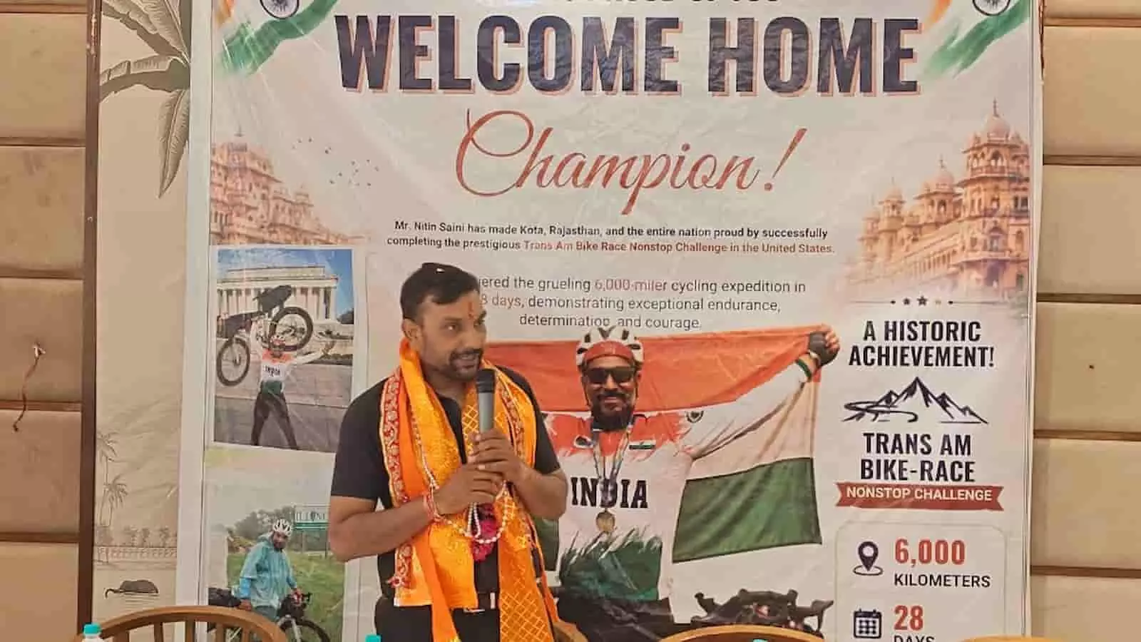 साइक्लिस्ट नितिन सैनी एक स्वागत बैनर के सामने खड़े होकर संबोधित कर रहे हैं। साइक्लिस्ट नितिन सैनी एक स्वागत बैनर के सामने खड़े होकर संबोधित कर रहे हैं।