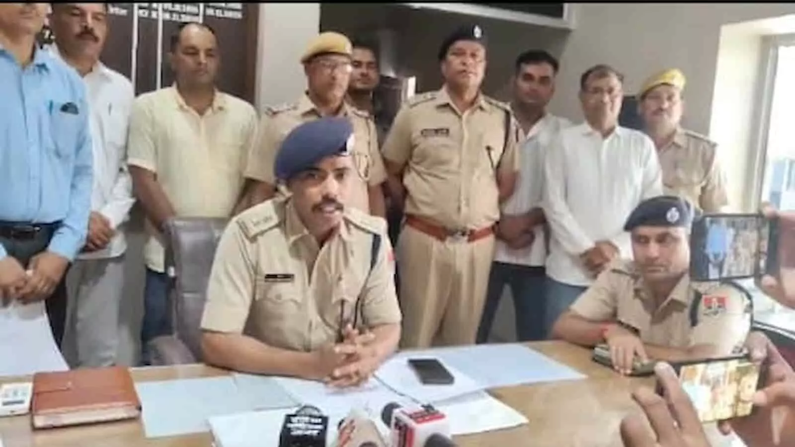तस्वीर में डीग पुलिस अधीक्षक और अन्य पुलिसकर्मी एक टेबल के पास बैठकर प्रेस वार्ता करते हुए दिख रहे हैं। तस्वीर में डीग पुलिस अधीक्षक और अन्य पुलिसकर्मी एक टेबल के पास बैठकर प्रेस वार्ता करते हुए दिख रहे हैं।