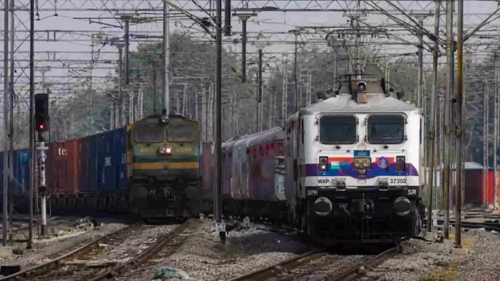 रेलवे ट्रैक पर एक साथ चलती हुई यात्री ट्रेन और मालगाड़ी की तस्वीर। रेलवे ट्रैक पर एक साथ चलती हुई यात्री ट्रेन और मालगाड़ी की तस्वीर।