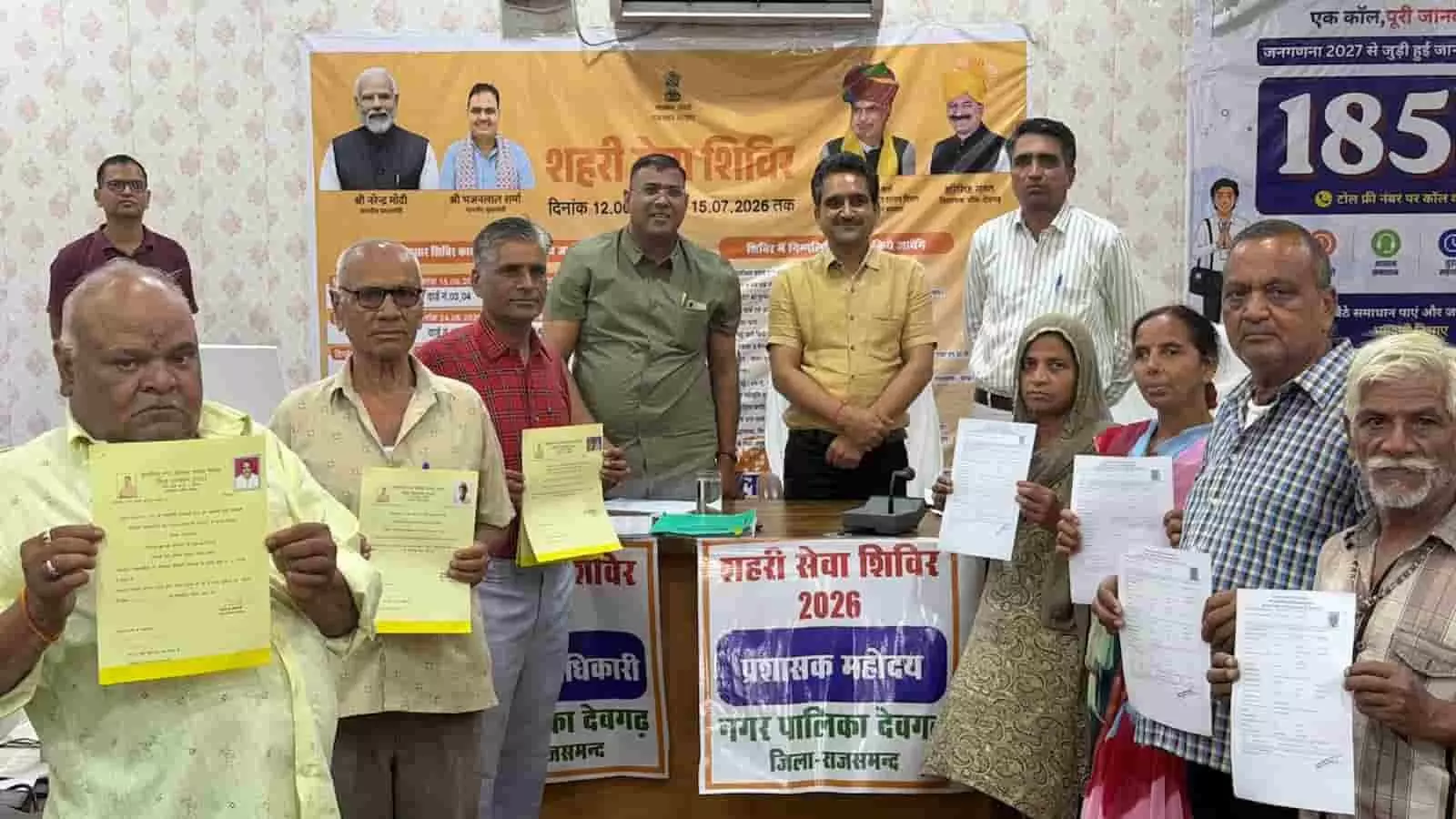 देवगढ़ के शहरी सेवा शिविर में अधिकारी लाभार्थियों को दस्तावेज प्रदान कर रहे हैं।