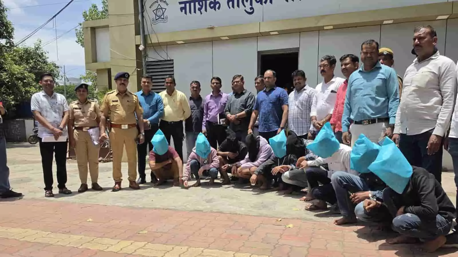नासिक पुलिस थाने के बाहर खड़े पुलिसकर्मी और चेहरे ढके हुए गिरफ्तार आरोपी। नासिक पुलिस थाने के बाहर खड़े पुलिसकर्मी और चेहरे ढके हुए गिरफ्तार आरोपी।