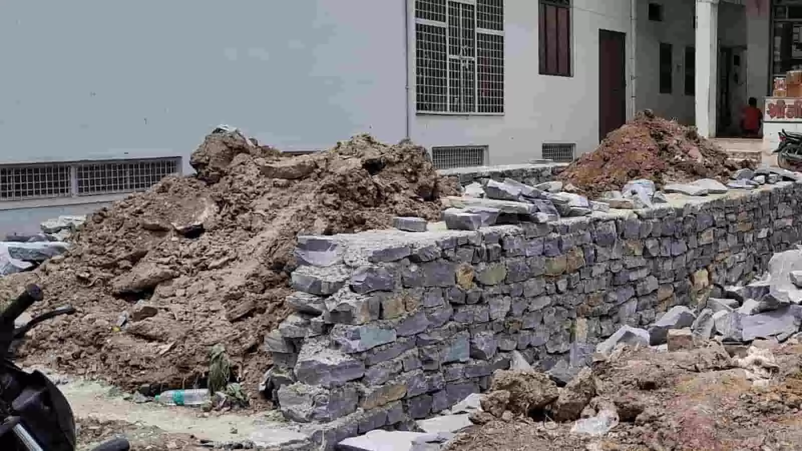तस्वीर में निर्माण के लिए पत्थरों की अधूरी दीवार और मिट्टी का ढेर दिखाई दे रहा है। तस्वीर में निर्माण के लिए पत्थरों की अधूरी दीवार और मिट्टी का ढेर दिखाई दे रहा है।