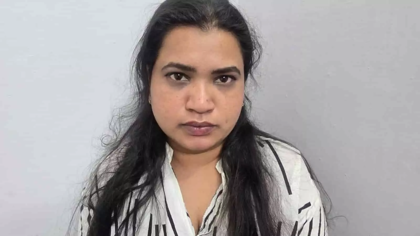 सफेद और काली धारीदार शर्ट पहने एक महिला अजमेर में पुलिस हिरासत के दौरान सीधे कैमरे की ओर देख रही है। सफेद और काली धारीदार शर्ट पहने एक महिला अजमेर में पुलिस हिरासत के दौरान सीधे कैमरे की ओर देख रही है।