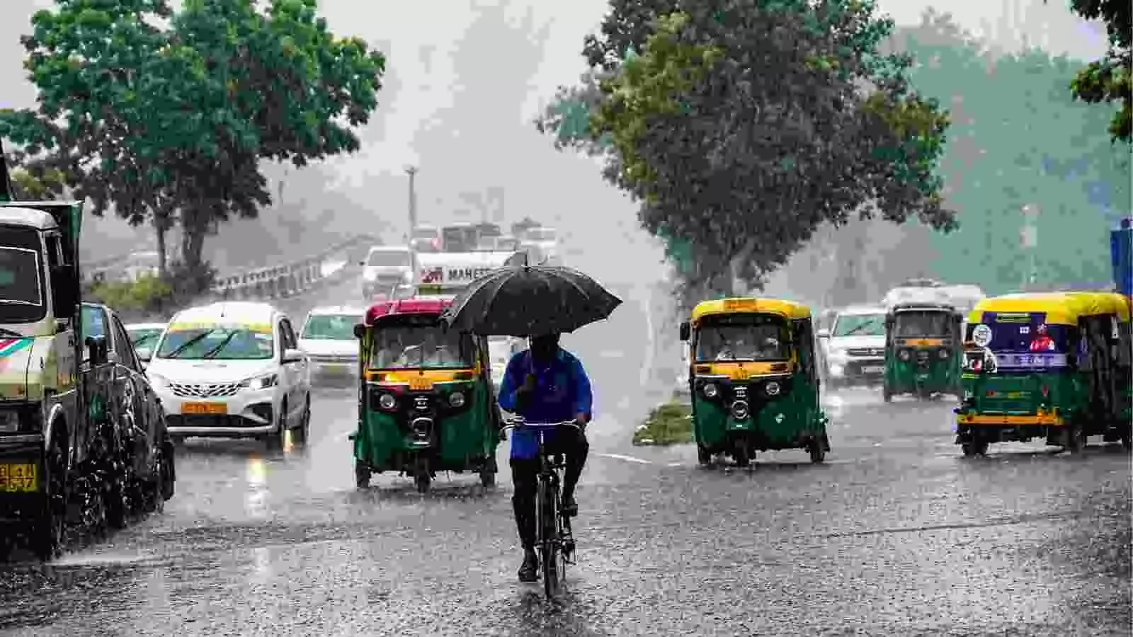 भारी बारिश के दौरान सड़क पर साइकिल चलाते व्यक्ति का दृश्य उत्तर भारत में। भारी बारिश के दौरान सड़क पर साइकिल चलाते व्यक्ति का दृश्य उत्तर भारत में।