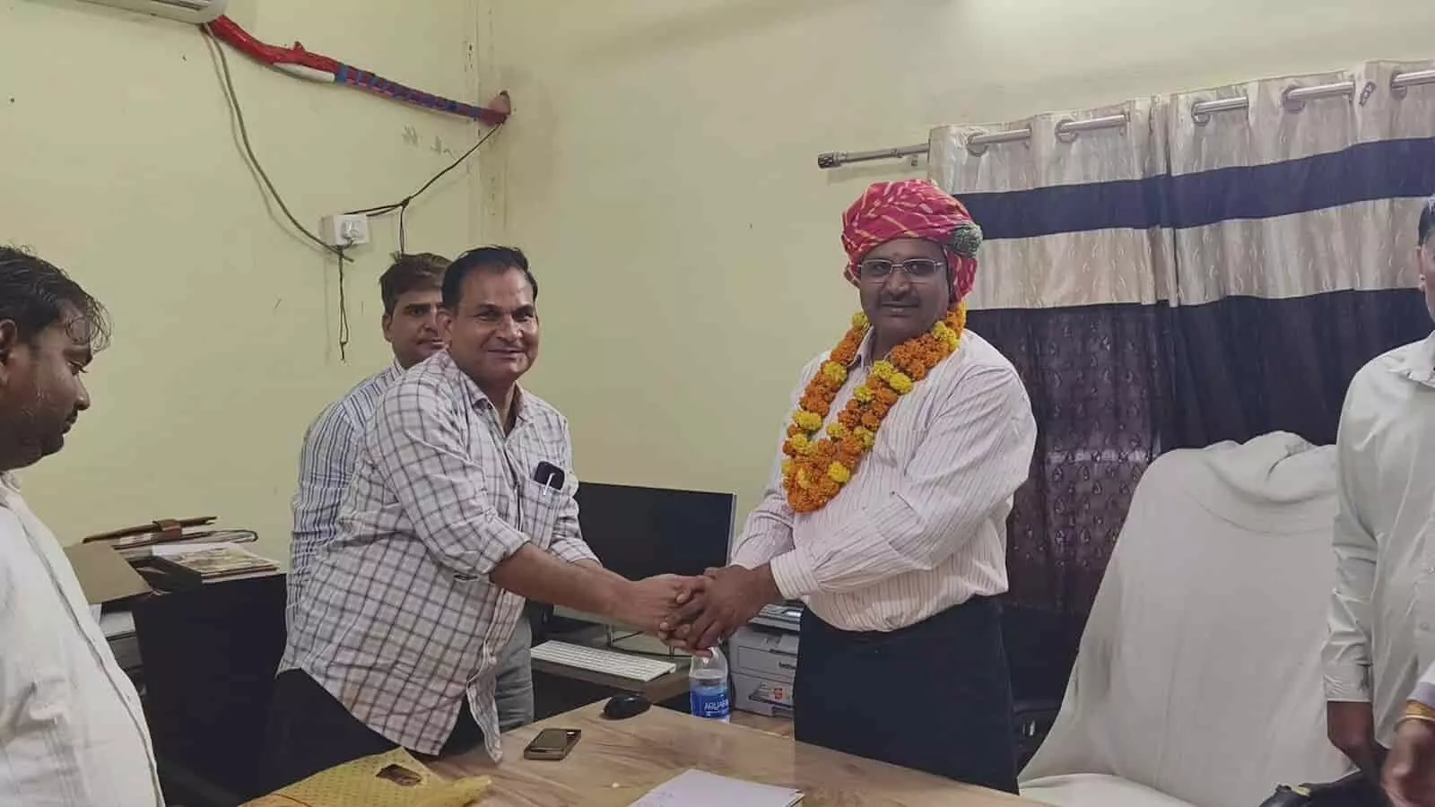 हिंडौन नगर परिषद कार्यालय में नवनियुक्त आयुक्त दिलीप कुमार शर्मा का साफा और माला पहनाकर स्वागत करते कर्मचारी।