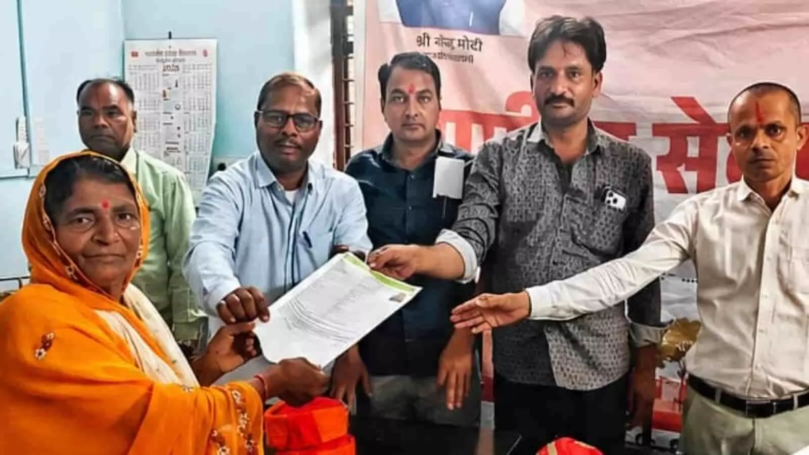 तस्वीर में अधिकारी एक बुजुर्ग महिला को ग्रामीण सेवा शिविर में पेंशन दस्तावेज सौंपते हुए दिख रहे हैं। तस्वीर में अधिकारी एक बुजुर्ग महिला को ग्रामीण सेवा शिविर में पेंशन दस्तावेज सौंपते हुए दिख रहे हैं।