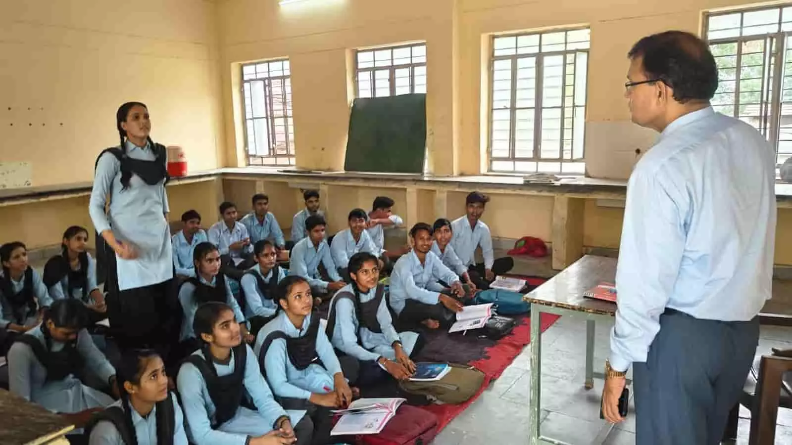 कक्षा में बैठे विद्यार्थियों से संवाद करते जिला शिक्षा अधिकारी स्कूल निरीक्षण के दौरान। कक्षा में बैठे विद्यार्थियों से संवाद करते जिला शिक्षा अधिकारी स्कूल निरीक्षण के दौरान।