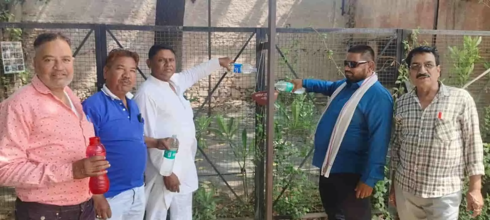 तस्वीर में भीलवाड़ा में पांच पुरुष लोहे की जाली के पास पक्षियों के परिंडे में पानी डालते हुए। तस्वीर में भीलवाड़ा में पांच पुरुष लोहे की जाली के पास पक्षियों के परिंडे में पानी डालते हुए।
