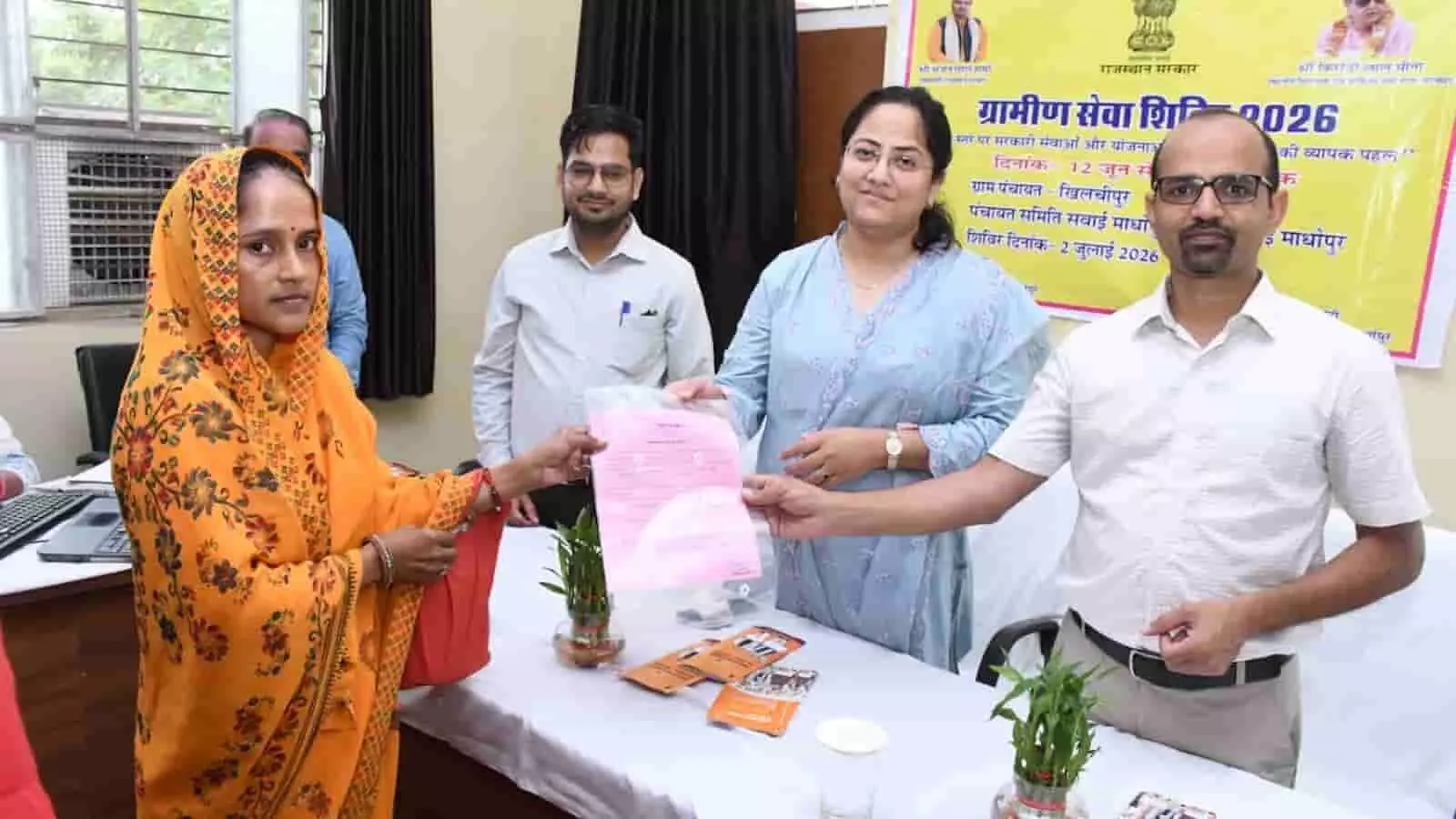 तस्वीर में ग्रामीण सेवा शिविर के दौरान अधिकारी एक ग्रामीण महिला को सरकारी प्रमाण-पत्र सौंप रहे हैं। तस्वीर में ग्रामीण सेवा शिविर के दौरान अधिकारी एक ग्रामीण महिला को सरकारी प्रमाण-पत्र सौंप रहे हैं।