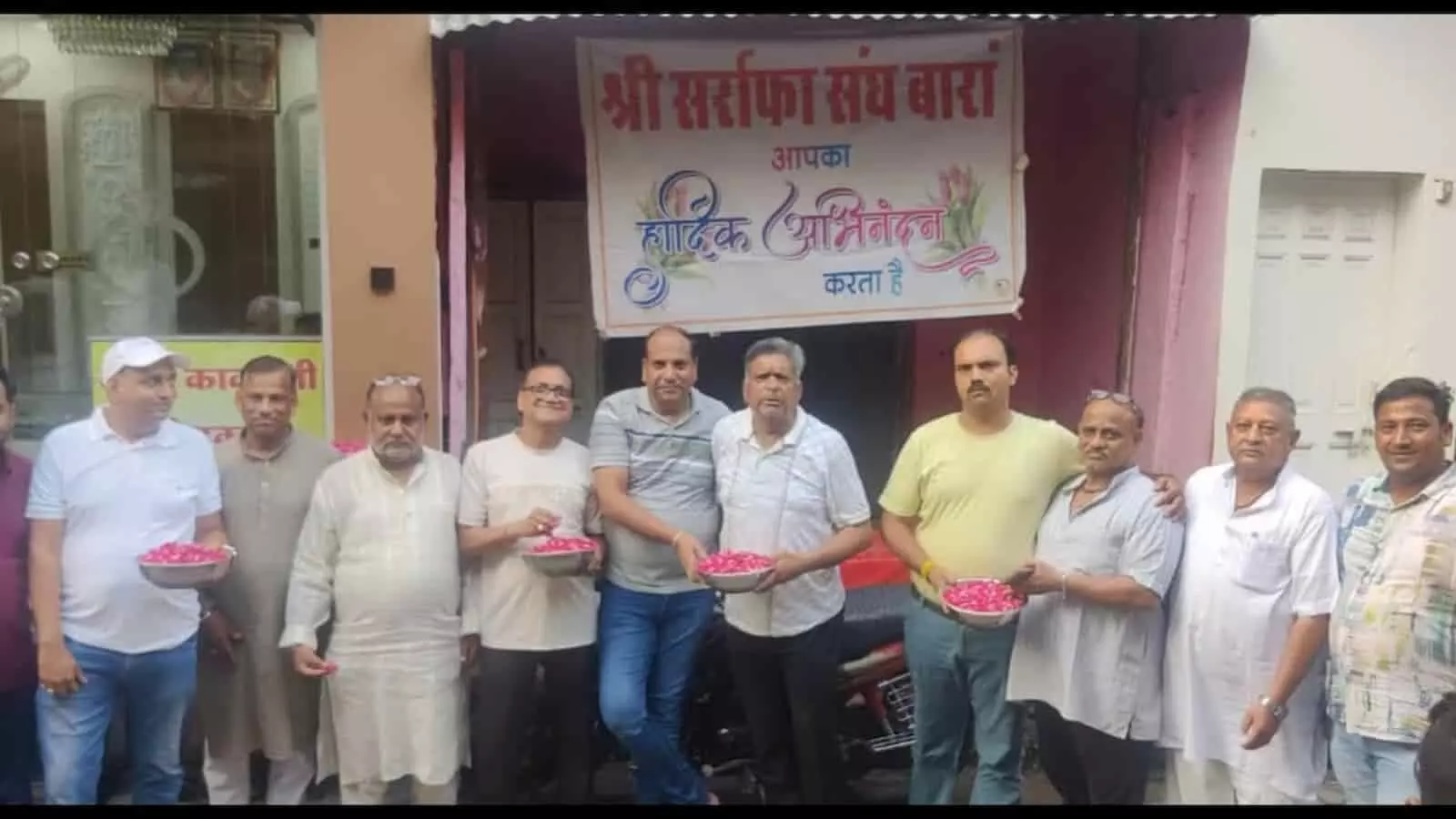बारां में श्री सर्राफा संघ के पदाधिकारी बैनर के नीचे फूलों के थाल लिए खड़े हैं। बारां में श्री सर्राफा संघ के पदाधिकारी बैनर के नीचे फूलों के थाल लिए खड़े हैं।