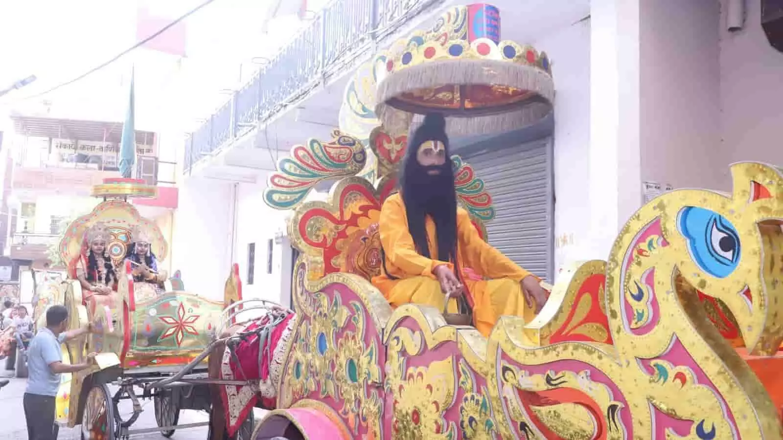 रथयात्रा में साधु के वेश में एक व्यक्ति रथ पर बैठे हुए दिख रहे हैं। रथयात्रा में साधु के वेश में एक व्यक्ति रथ पर बैठे हुए दिख रहे हैं।