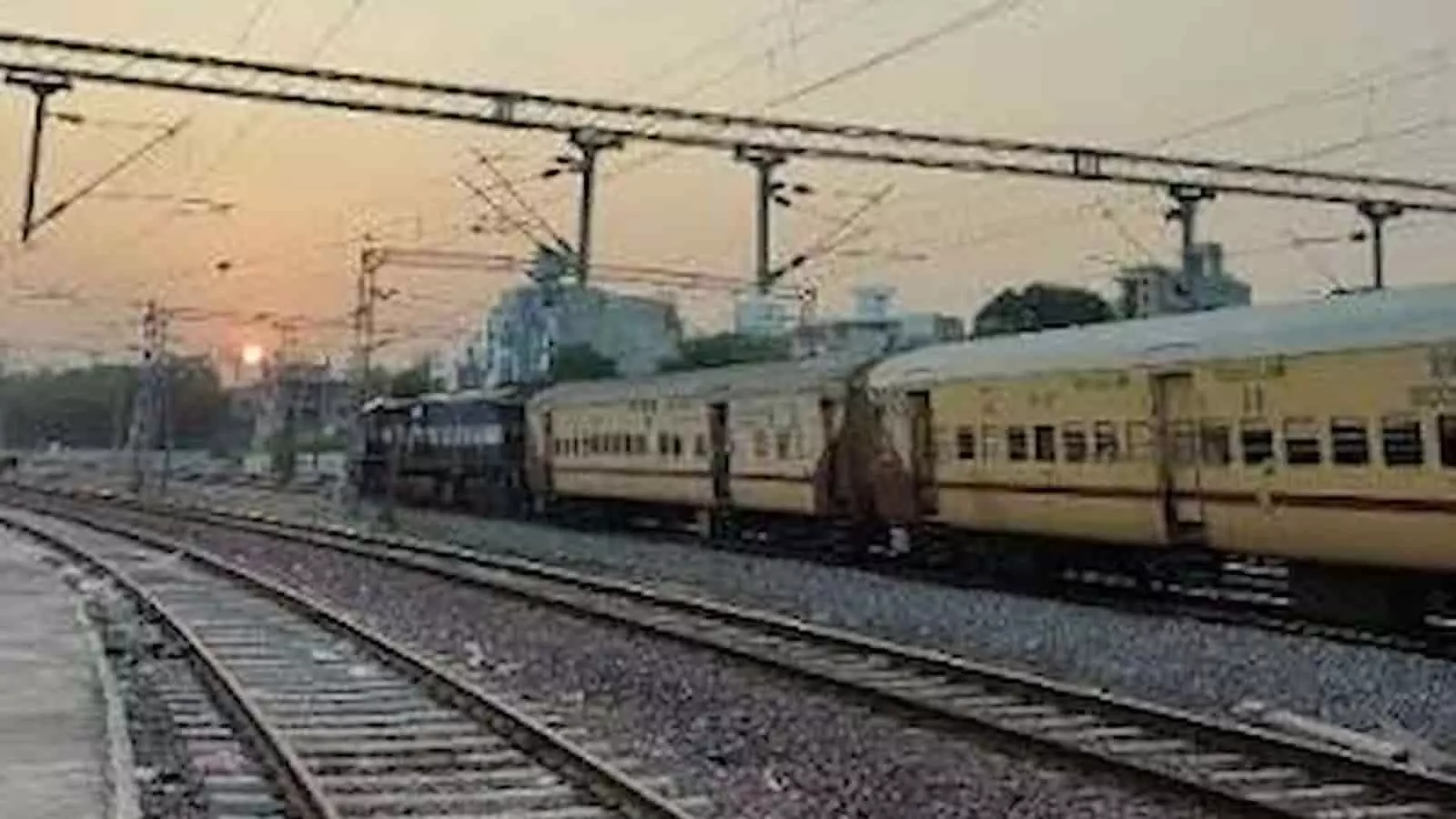 रेलवे स्टेशन पर पटरियों पर खड़ी एक ट्रेन दिन के समय दिखाई दे रही है। रेलवे स्टेशन पर पटरियों पर खड़ी एक ट्रेन दिन के समय दिखाई दे रही है।