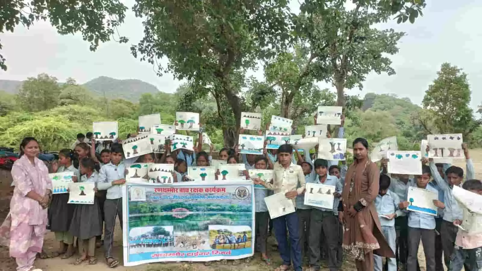 तस्वीर में रणथंभौर बाघ रक्षक कार्यक्रम के बैनर के साथ जागरूकता चार्ट दिखाते स्कूली बच्चे। तस्वीर में रणथंभौर बाघ रक्षक कार्यक्रम के बैनर के साथ जागरूकता चार्ट दिखाते स्कूली बच्चे।