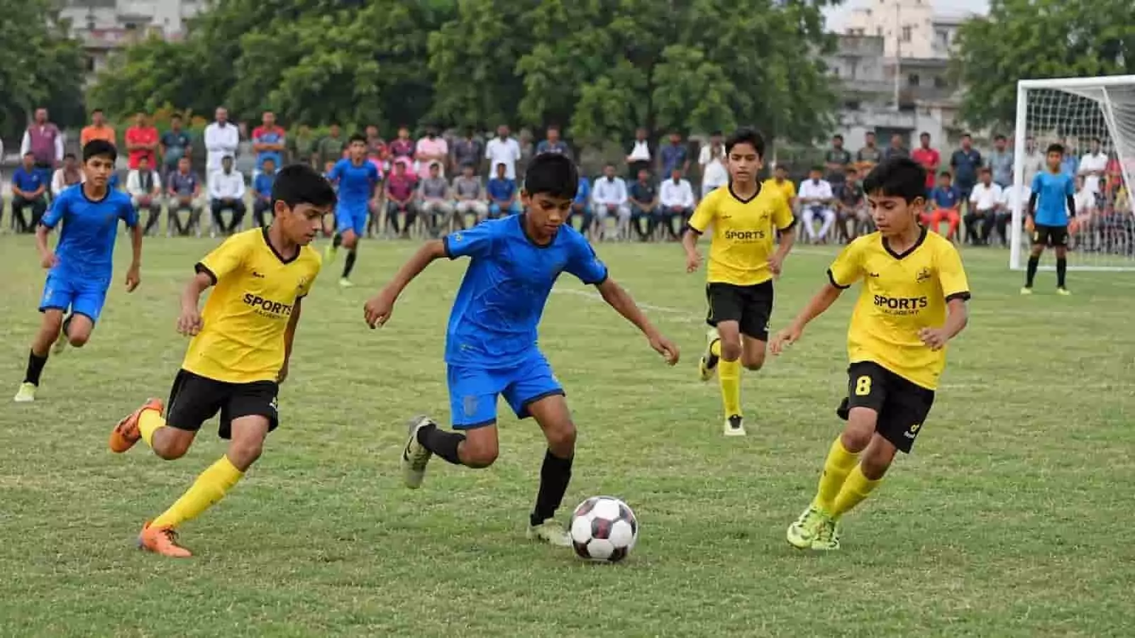 भीलवाड़ा के मैदान पर फुटबॉल मैच के दौरान गेंद को ड्रिबल करते हुए बच्चे। भीलवाड़ा के मैदान पर फुटबॉल मैच के दौरान गेंद को ड्रिबल करते हुए बच्चे।