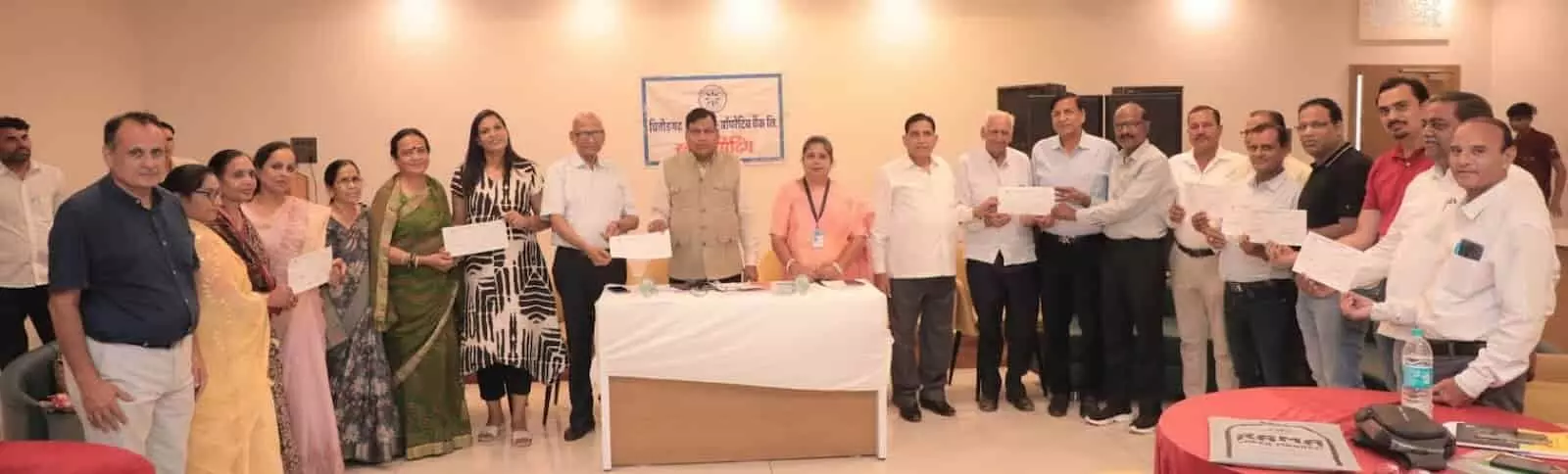 अर्बन कोऑपरेटिव बैंक के पदाधिकारी इनडोर कार्यक्रम में दस्तावेज लेकर मंच पर उपस्थित हैं। अर्बन कोऑपरेटिव बैंक के पदाधिकारी इनडोर कार्यक्रम में दस्तावेज लेकर मंच पर उपस्थित हैं।