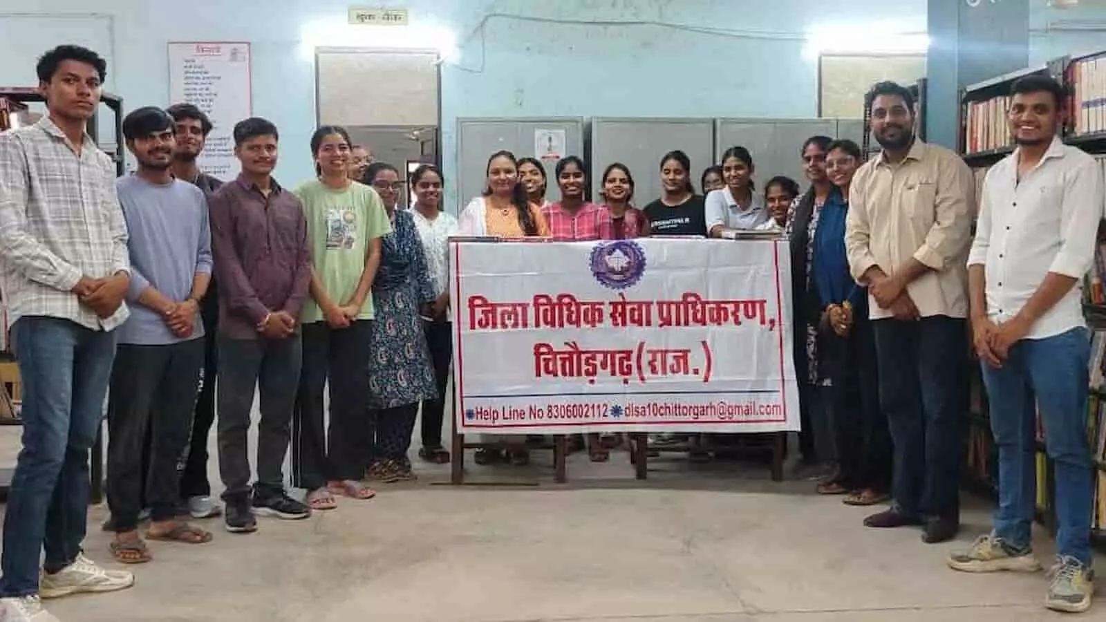 विधिक जागरूकता शिविर में जिला विधिक सेवा प्राधिकरण के बैनर के पीछे खड़े लोग। विधिक जागरूकता शिविर में जिला विधिक सेवा प्राधिकरण के बैनर के पीछे खड़े लोग।