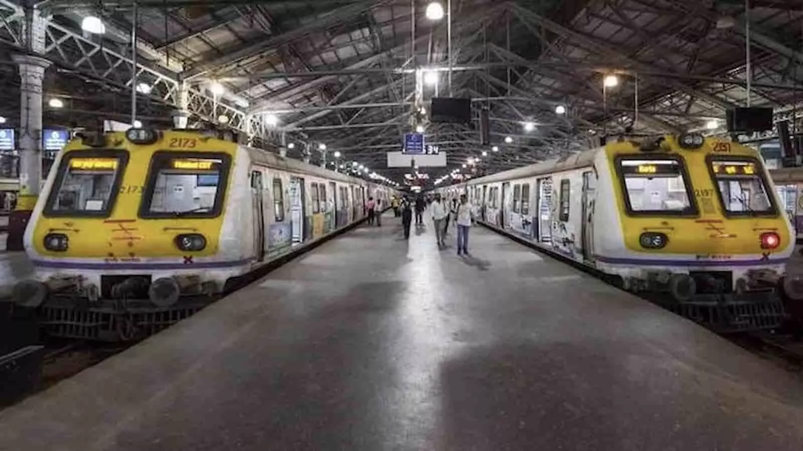 रेलवे स्टेशन के प्लेटफॉर्म पर खड़ी दो मुंबई लोकल ट्रेनें और चलते हुए रेल यात्री। रेलवे स्टेशन के प्लेटफॉर्म पर खड़ी दो मुंबई लोकल ट्रेनें और चलते हुए रेल यात्री।