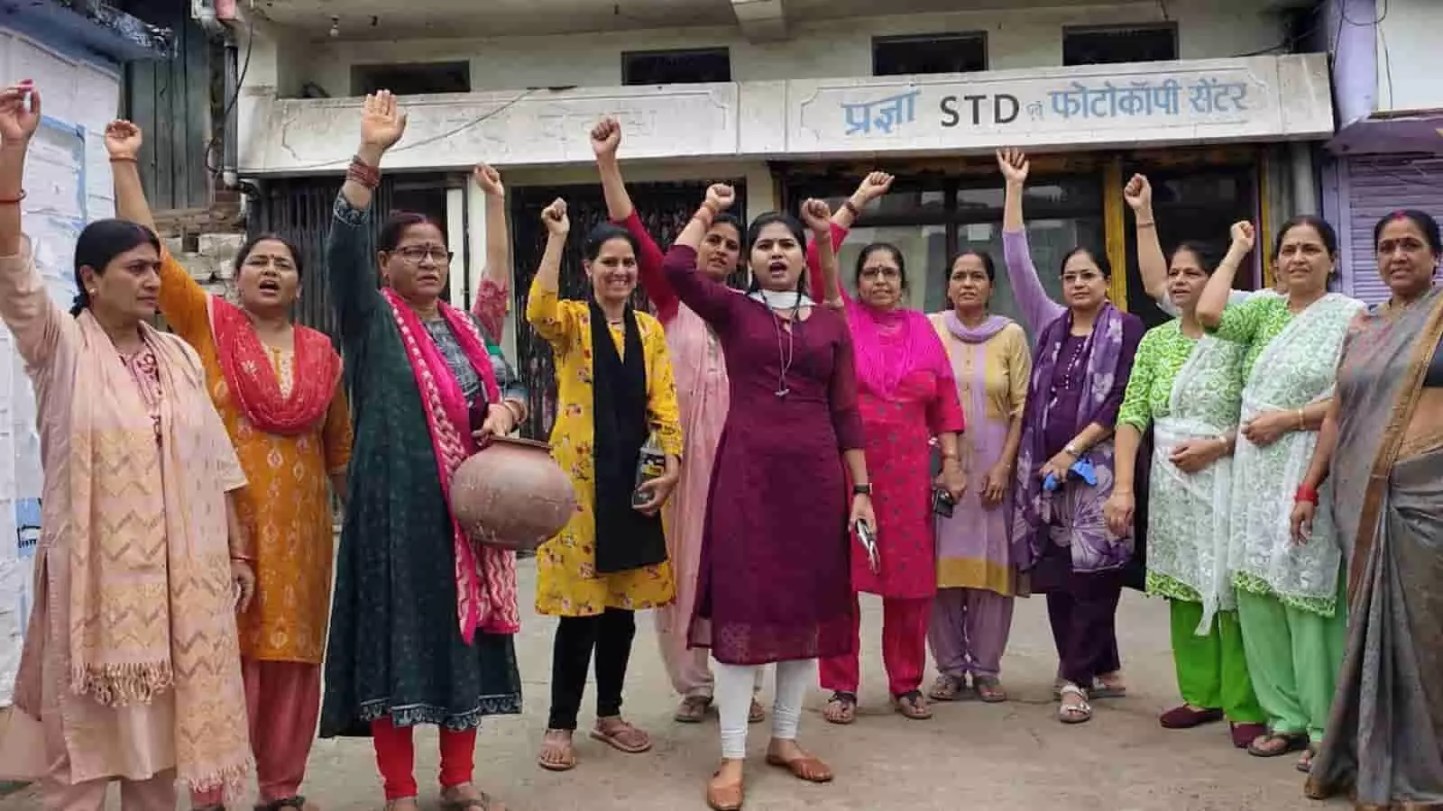 तस्वीर में महिलाएं दुकान के सामने मटका लेकर नारेबाजी और विरोध प्रदर्शन करती हुई दिख रही हैं। तस्वीर में महिलाएं दुकान के सामने मटका लेकर नारेबाजी और विरोध प्रदर्शन करती हुई दिख रही हैं।