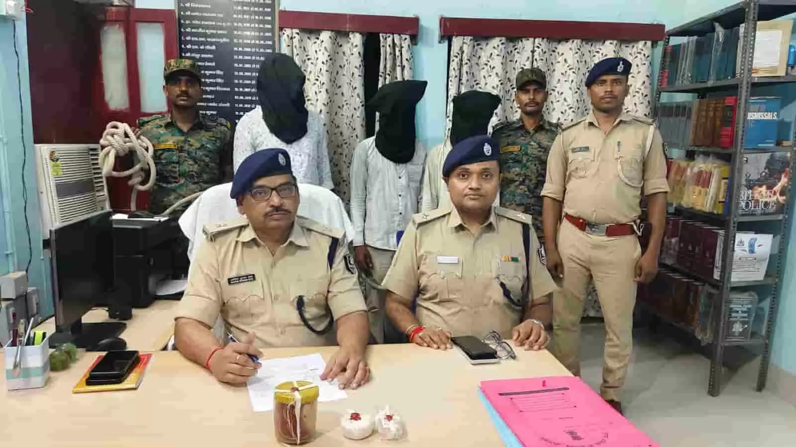 तस्वीर में दिख रहा है कि औरंगाबाद जिले के एक पुलिस थाने के भीतर दो पुलिस अधिकारी कुर्सी पर बैठे हैं, जबकि उनके पीछे तीन वर्दीधारी पुलिसकर्मी और काले कपड़े से चेहरा ढके तीन आरोपी खड़े हैं।