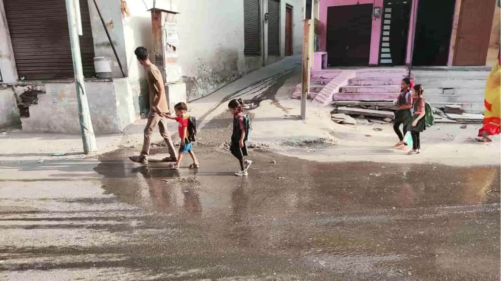 खमनोर में सड़क पर जमा गंदे पानी से बचकर निकलते स्कूली बच्चे और राहगीर। खमनोर में सड़क पर जमा गंदे पानी से बचकर निकलते स्कूली बच्चे और राहगीर।