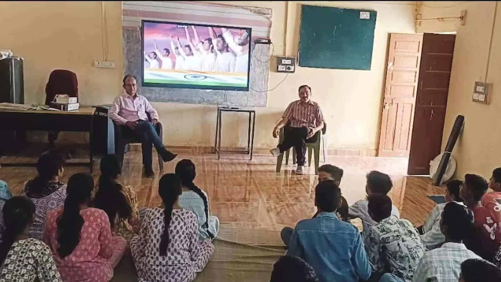 विद्यालय में स्क्रीन के सामने बैठकर लोकतंत्र की जानकारी लेते स्कूली विद्यार्थी। विद्यालय में स्क्रीन के सामने बैठकर लोकतंत्र की जानकारी लेते स्कूली विद्यार्थी।