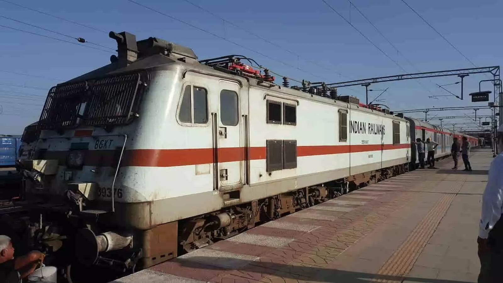 प्लेटफॉर्म पर खड़ा भारतीय रेल का इंजन और वहां मौजूद कुछ यात्री। प्लेटफॉर्म पर खड़ा भारतीय रेल का इंजन और वहां मौजूद कुछ यात्री।
