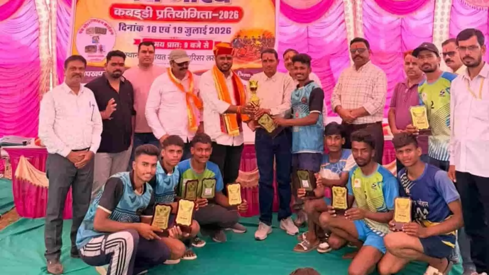 तस्वीर में लसाडिया पंचायत समिति परिसर में मंच पर ट्रॉफी के साथ कबड्डी प्रतियोगिता के खिलाड़ी और अतिथि दिख रहे हैं। तस्वीर में लसाडिया पंचायत समिति परिसर में मंच पर ट्रॉफी के साथ कबड्डी प्रतियोगिता के खिलाड़ी और अतिथि दिख रहे हैं।