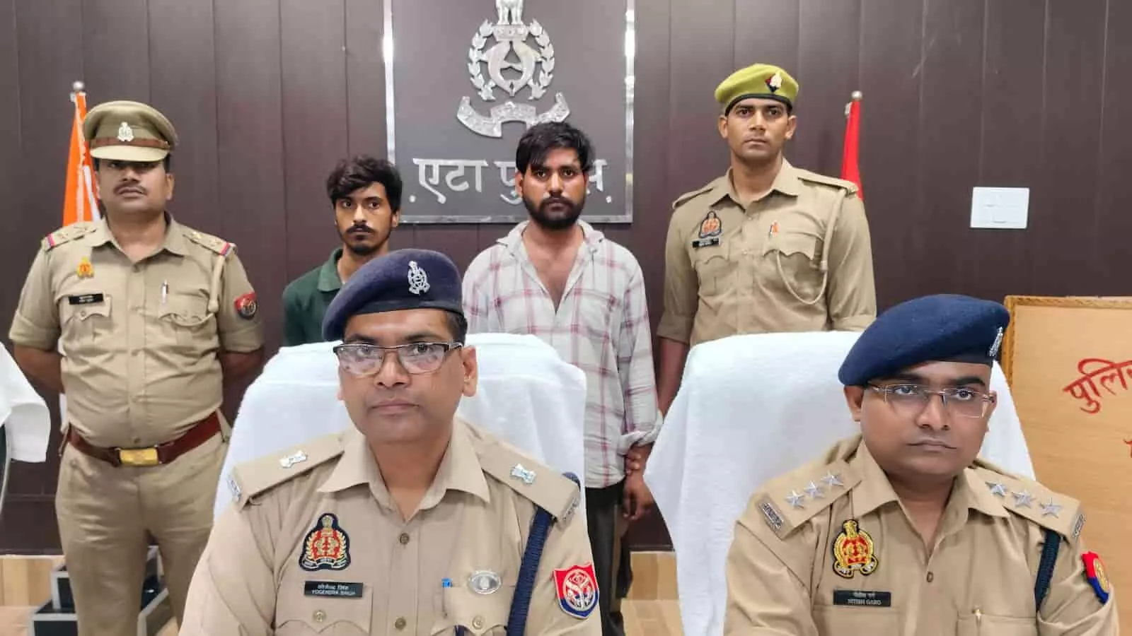 पुलिस अधिकारियों के साथ खड़े दो गिरफ्तार साइबर आरोपी एटा कार्यालय में।