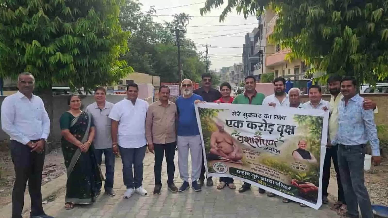 राष्ट्रीय गुरु आस्था परिवार के सदस्य कोटा में पौधारोपण अभियान के पोस्टर के साथ खड़े हैं।