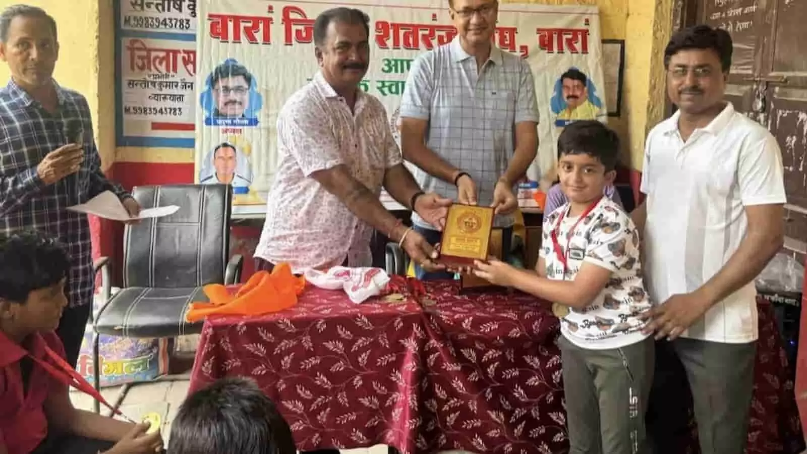 बारां में शतरंज प्रतियोगिता के पुरस्कार वितरण समारोह के दौरान अतिथि बालक को ट्रॉफी देते हुए। बारां में शतरंज प्रतियोगिता के पुरस्कार वितरण समारोह के दौरान अतिथि बालक को ट्रॉफी देते हुए।