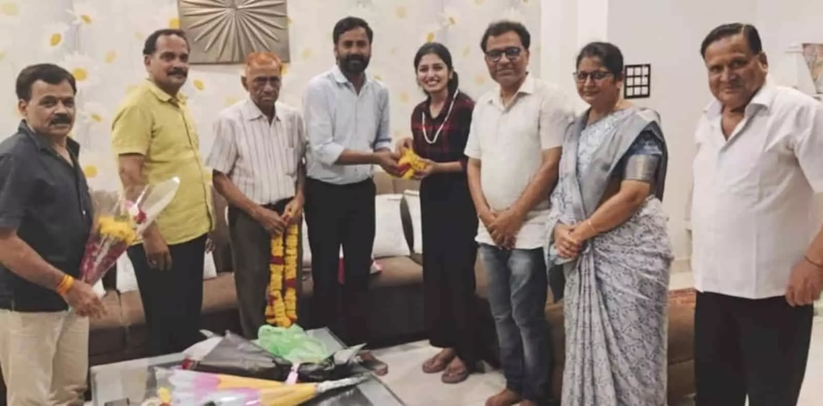 कपड़ा व्यापार समिति के पदाधिकारी और सदस्य एक घर में खड़े होकर दिखाई दे रहे हैं।