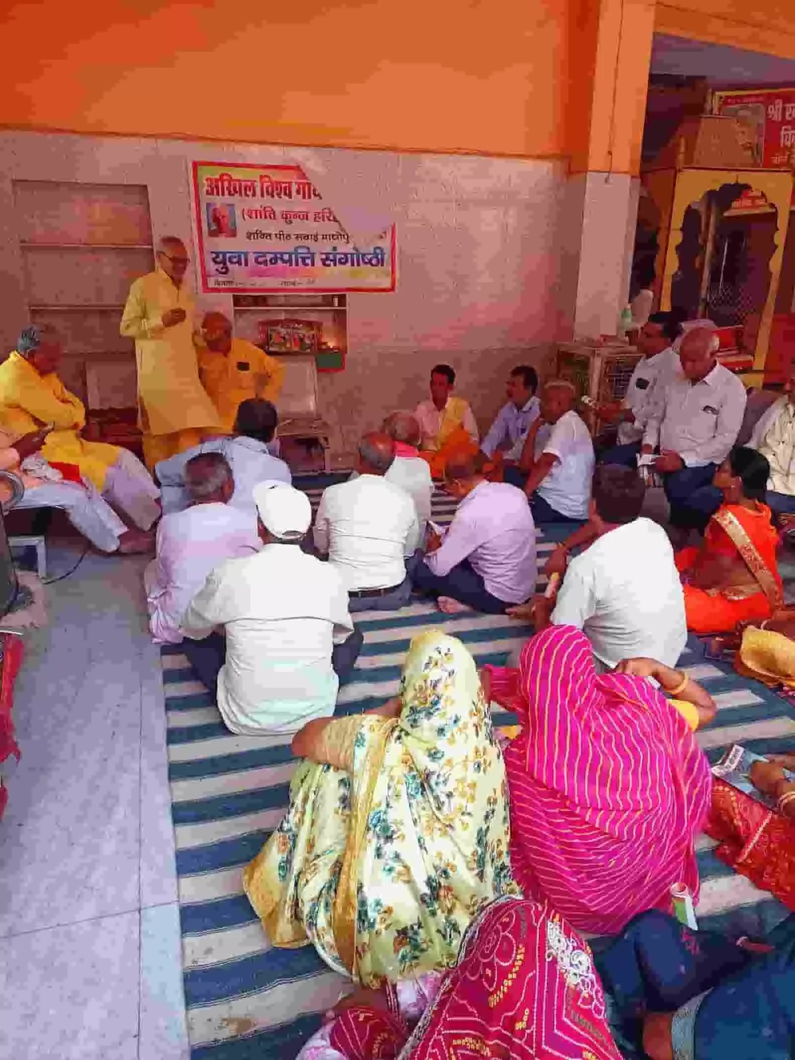 तस्वीर में बौली के खेड़ापति बालाजी परिसर में युवा दंपति संगोष्ठी के दौरान उपस्थित लोग फर्श पर बैठे हुए दिख रहे हैं।