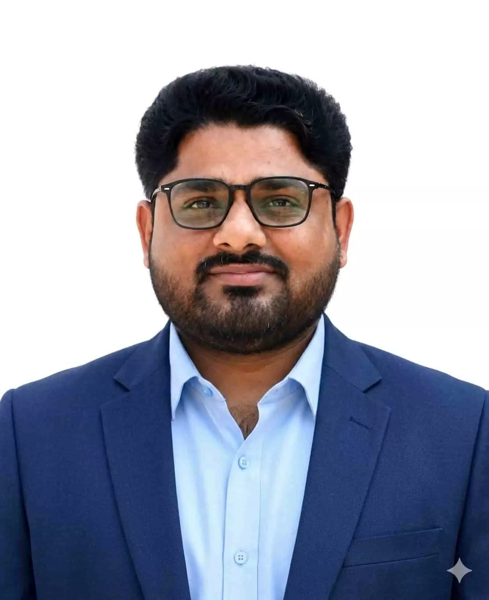 एक औपचारिक पोर्ट्रेट में डॉ. राजेंद्र मीणा सफेद बैकग्राउंड के सामने नीले सूट में दिख रहे हैं।