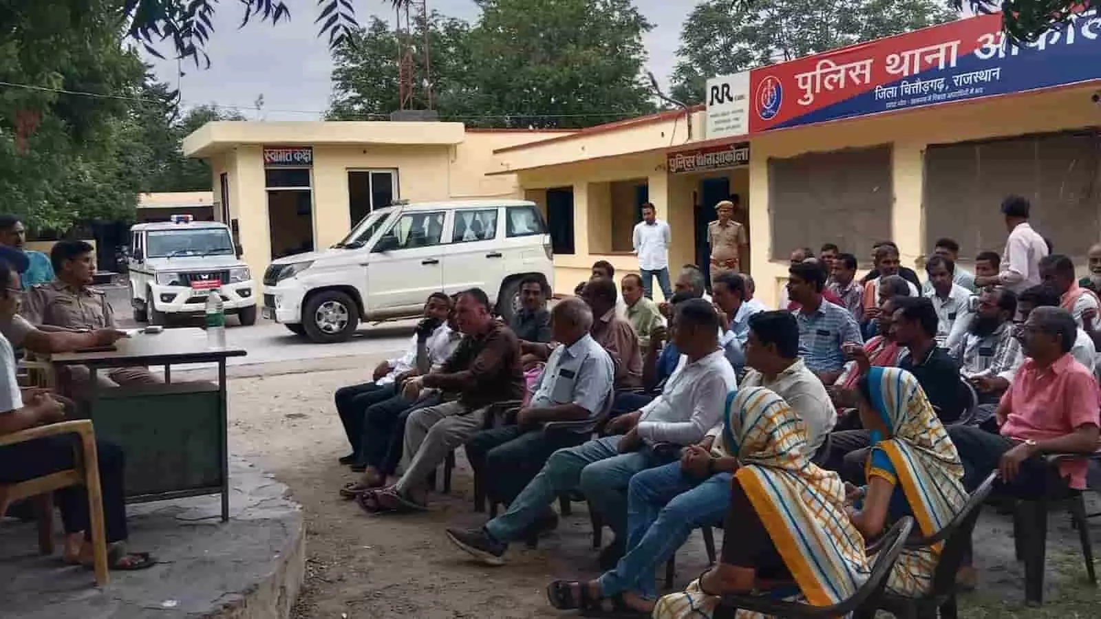 तस्वीर में आकोला पुलिस थाना परिसर के बाहर कुर्सियों पर बैठकर बैठक करते अधिकारी और स्थानीय नागरिक। तस्वीर में आकोला पुलिस थाना परिसर के बाहर कुर्सियों पर बैठकर बैठक करते अधिकारी और स्थानीय नागरिक।