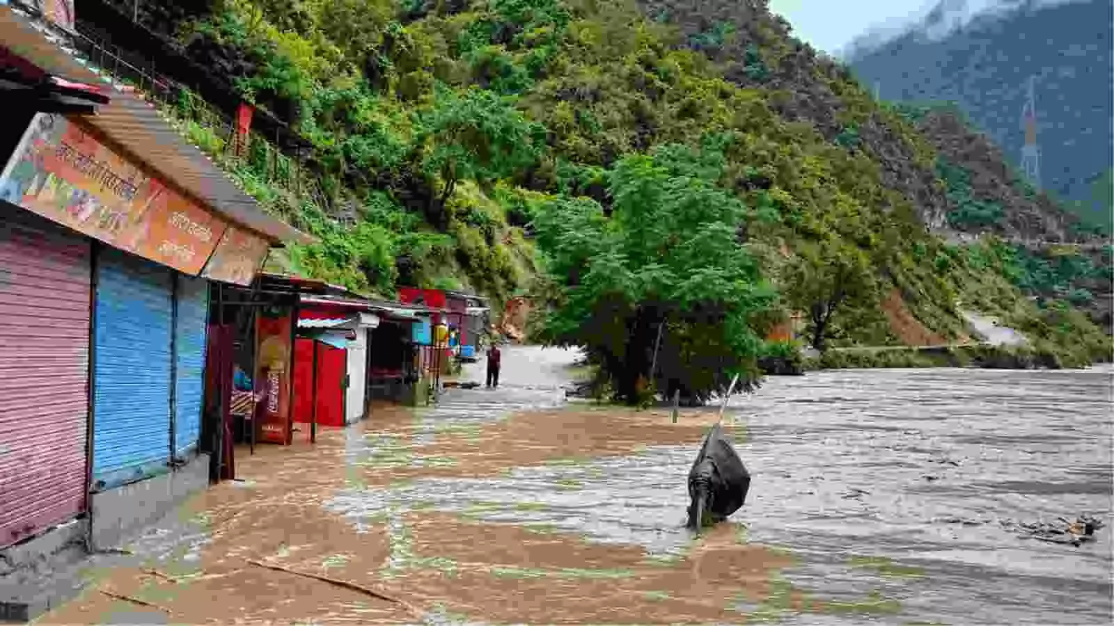 उत्तराखंड में भारी बारिश के कारण बढ़े हुए जलस्तर और बाढ़ की स्थिति में पानी में डूबी दुकानें नजर आ रही हैं।