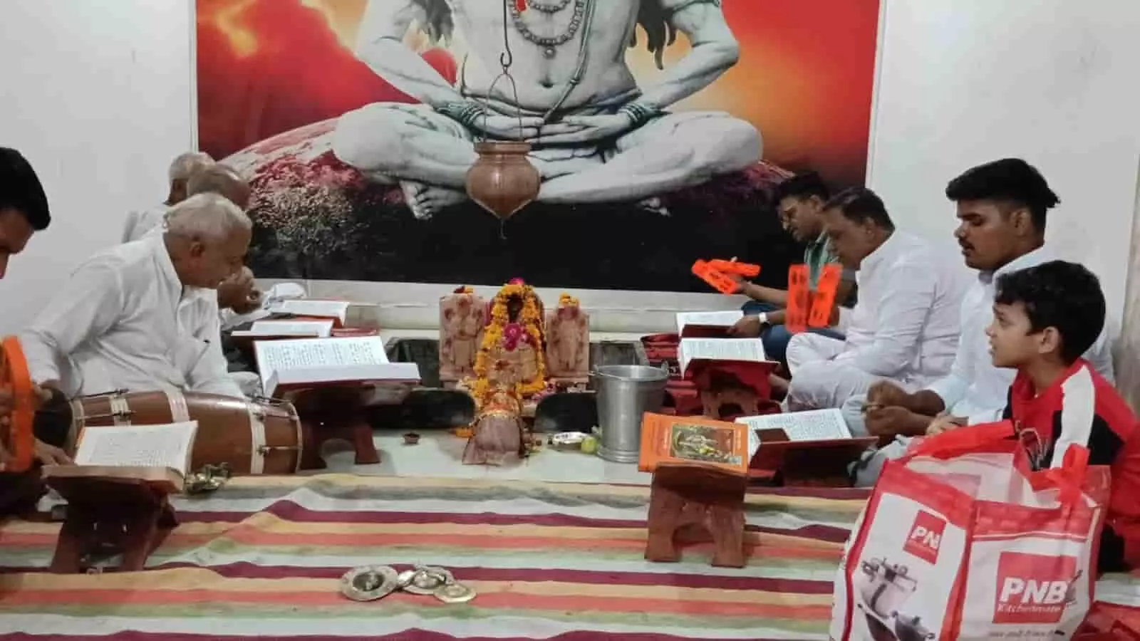 तस्वीर में अखाड़े के अंदर जमीन पर बैठकर श्रद्धालु धार्मिक पुस्तक का पाठ कर रहे हैं। तस्वीर में अखाड़े के अंदर जमीन पर बैठकर श्रद्धालु धार्मिक पुस्तक का पाठ कर रहे हैं।