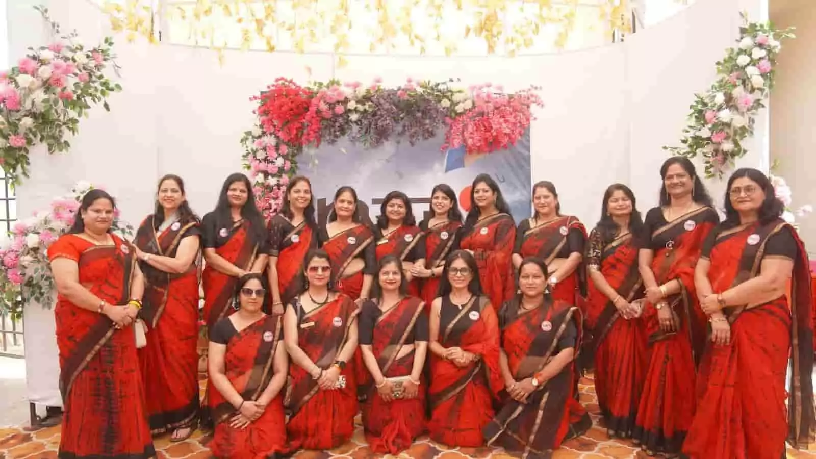 लाल और काले रंग की साड़ियों में जेसीआई कोटा शक्ति की महिला सदस्य प्रदर्शनी स्थल पर खड़ी हैं।