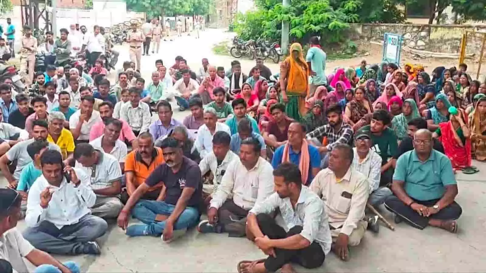 तस्वीर में अस्पताल के बाहर सड़क पर बैठे प्रदर्शनकारी पुरुष और महिलाएं न्याय की मांग करते दिख रहे हैं। तस्वीर में अस्पताल के बाहर सड़क पर बैठे प्रदर्शनकारी पुरुष और महिलाएं न्याय की मांग करते दिख रहे हैं।
