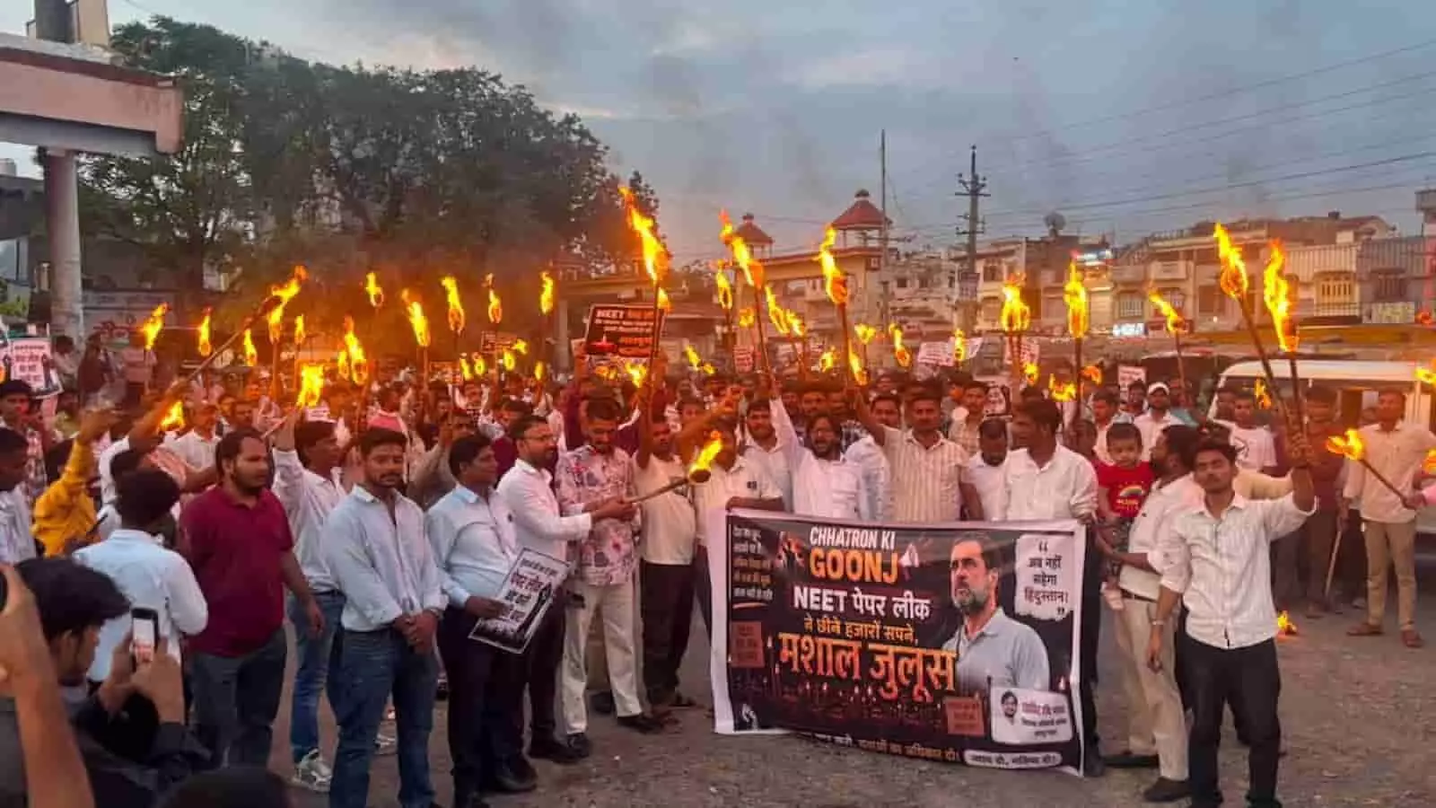 तस्वीर में सड़क पर बैनर और मशालें थामे लोग नीट पेपर लीक के खिलाफ प्रदर्शन करते दिख रहे हैं। तस्वीर में सड़क पर बैनर और मशालें थामे लोग नीट पेपर लीक के खिलाफ प्रदर्शन करते दिख रहे हैं।