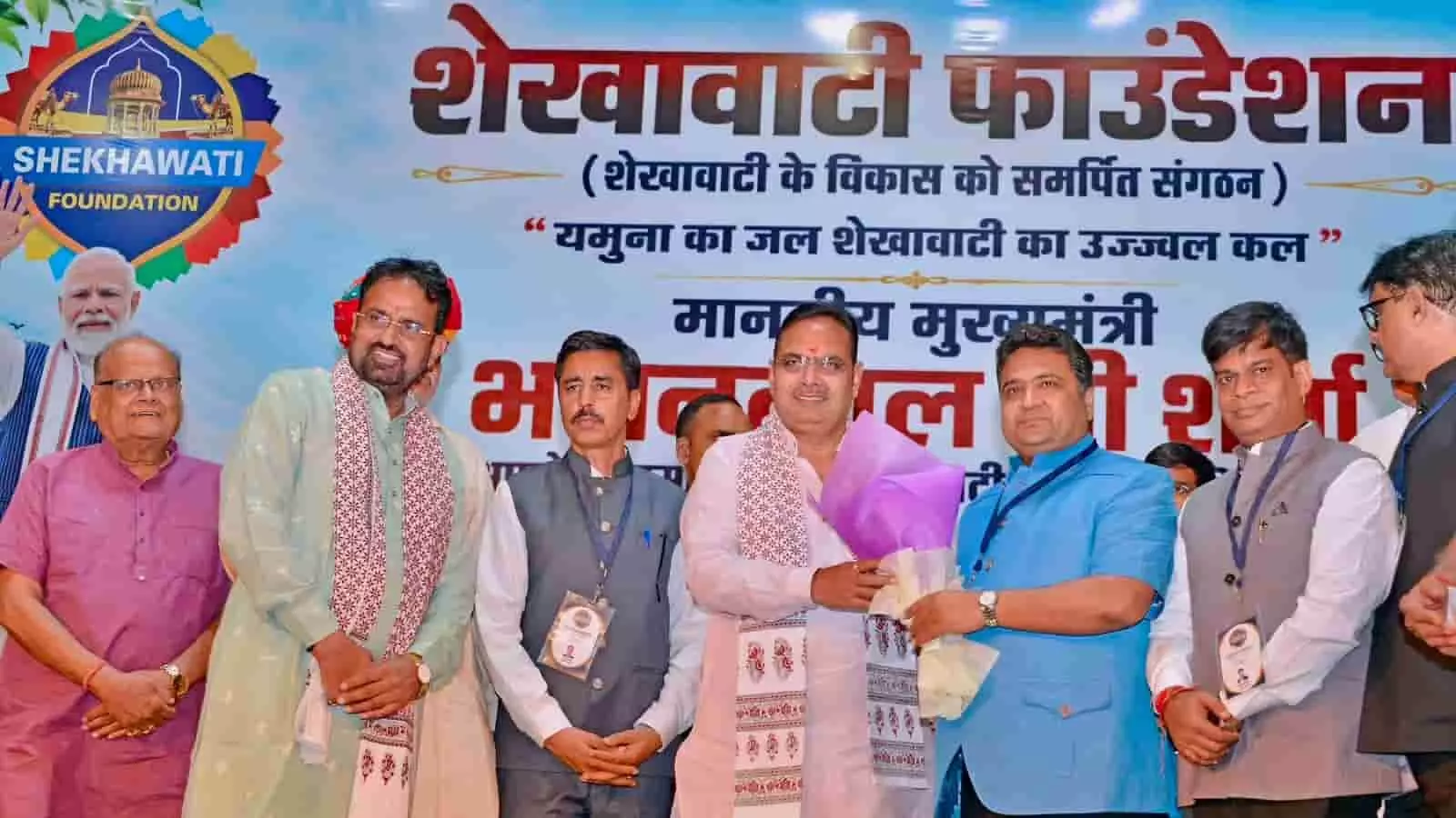 तस्वीर में जयपुर के कार्यक्रम के दौरान मुख्यमंत्री भजनलाल शर्मा को गुलदस्ता भेंट किया जा रहा है।