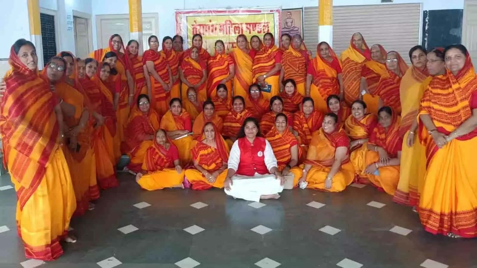 आमेट के तेरापंथ सभा भवन में पीली और लाल साड़ी पहने एक साथ बैठीं और खड़ी महिलाएं। आमेट के तेरापंथ सभा भवन में पीली और लाल साड़ी पहने एक साथ बैठीं और खड़ी महिलाएं।