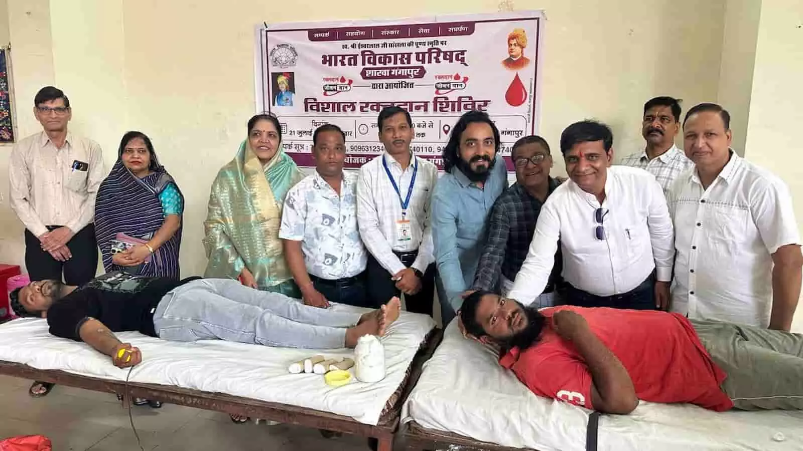 गंगापुर में रक्तदान शिविर के दौरान बिस्तर पर लेटे रक्तदाताओं और उपस्थित गणमान्य नागरिकों का समूह। गंगापुर में रक्तदान शिविर के दौरान बिस्तर पर लेटे रक्तदाताओं और उपस्थित गणमान्य नागरिकों का समूह।