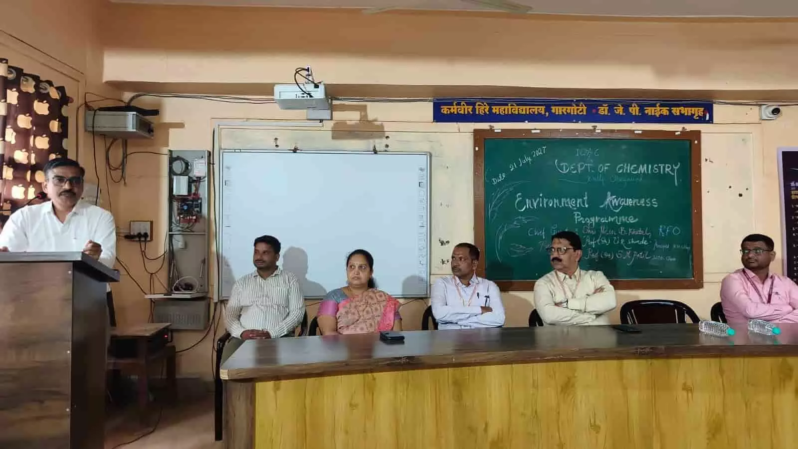 तस्वीर में कर्मवीर हिरे महाविद्यालय के सभागृह में मंच पर बैठे अतिथि और पॉडियम पर भाषण देते वक्ता दिख रहे हैं। तस्वीर में कर्मवीर हिरे महाविद्यालय के सभागृह में मंच पर बैठे अतिथि और पॉडियम पर भाषण देते वक्ता दिख रहे हैं।