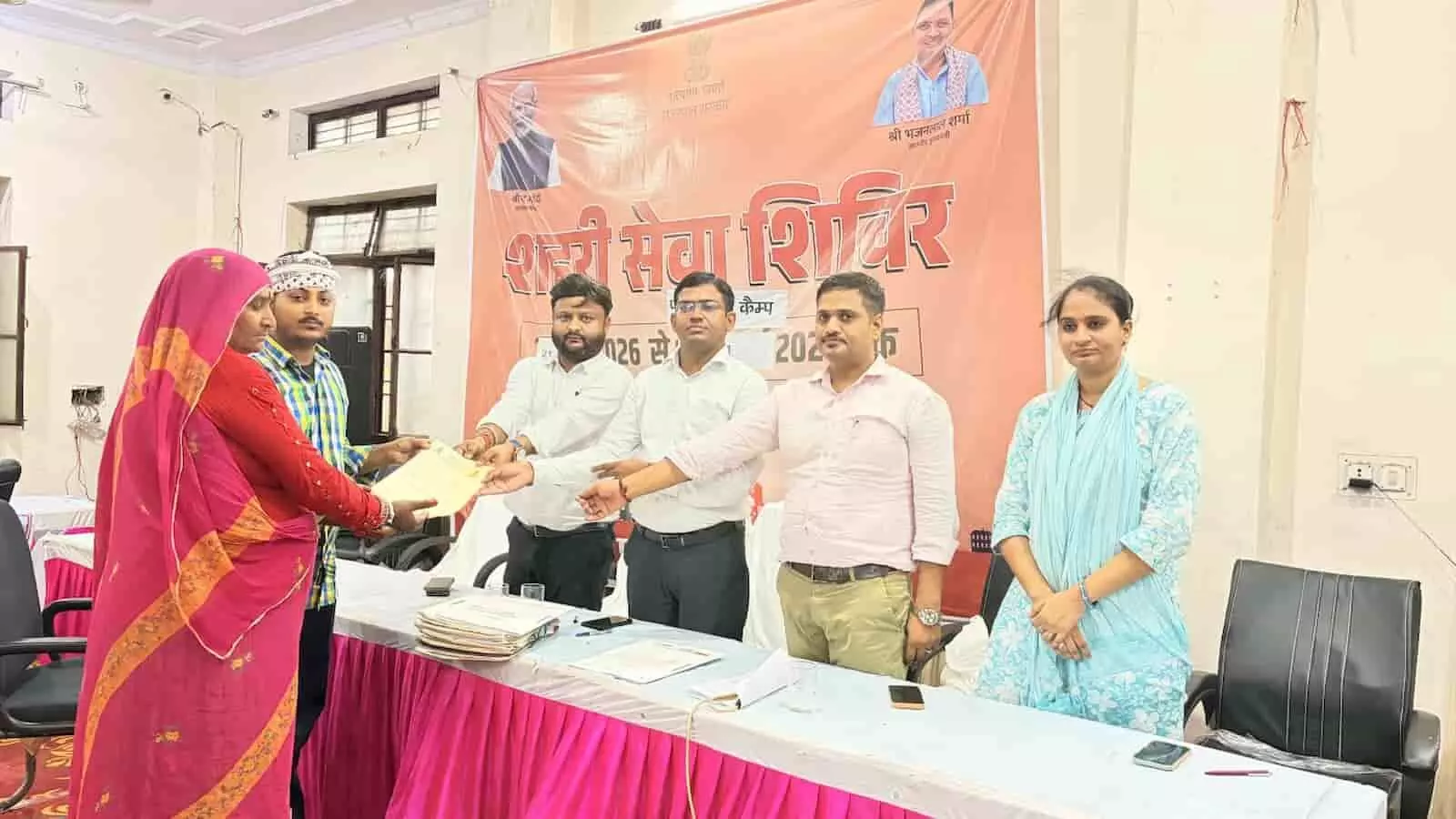 तस्वीर में नगर परिषद सभागार में फॉलोअप शहरी सेवा शिविर के दौरान नागरिक और अधिकारी मौजूद हैं। तस्वीर में नगर परिषद सभागार में फॉलोअप शहरी सेवा शिविर के दौरान नागरिक और अधिकारी मौजूद हैं।