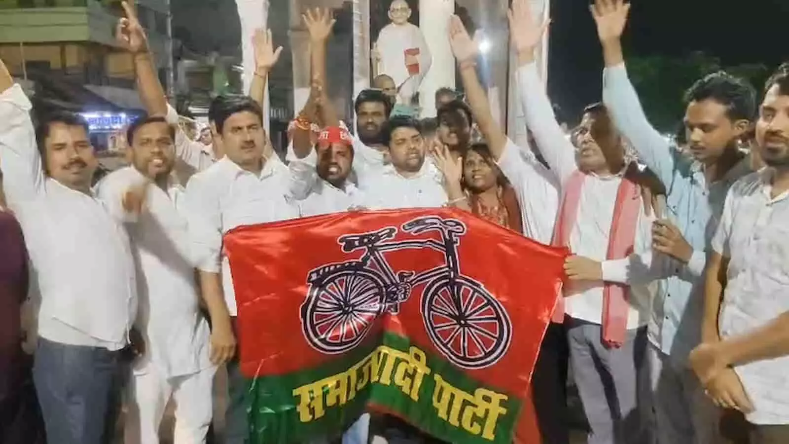 तस्वीर में समाजवादी पार्टी के नेता कन्नौज में झंडा लेकर प्रदर्शन कर रहे हैं।